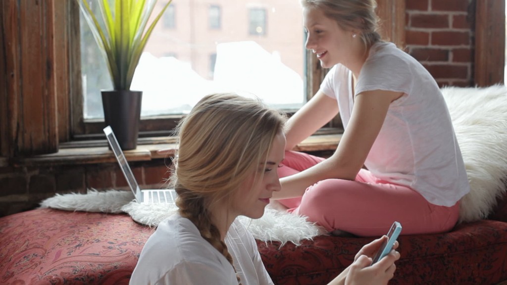 stock-footage-friends-hang-out-in-beautiful-urban-loft-do-homework-and-joke-around-on-their-phone-and-laptop